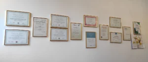 Dyplomu i certyfikaty powieszone na ścianie gabinetu dietetycznego